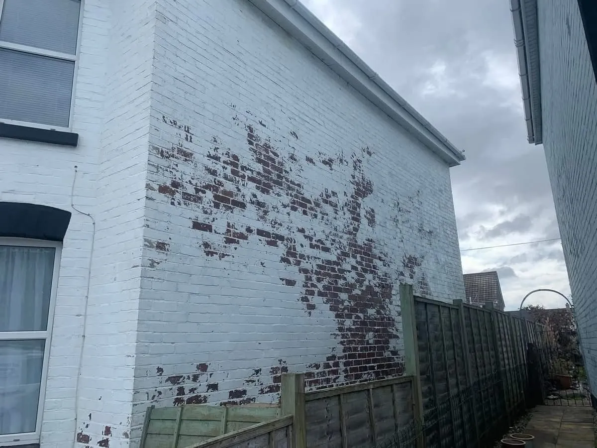 Peeling paint on a brick wall before redecoration in Penzance